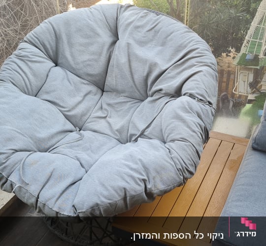 כיסא מרופד ומרפסת עם צמחייה